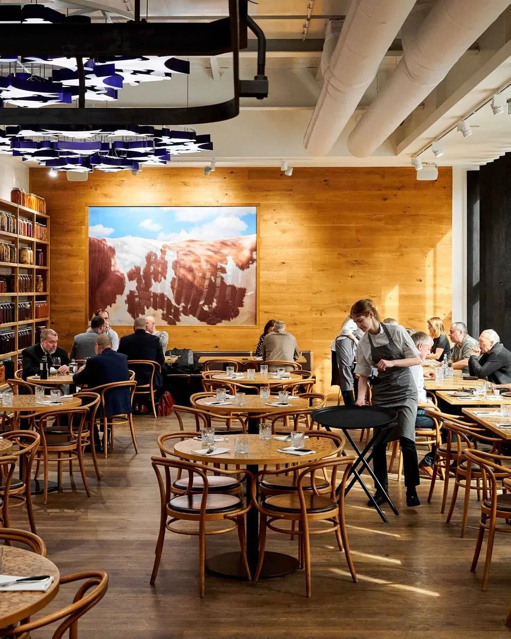 Interiér restaurace Čestr s dřevěným nábytkem a otevřeným jídelním prostorem.