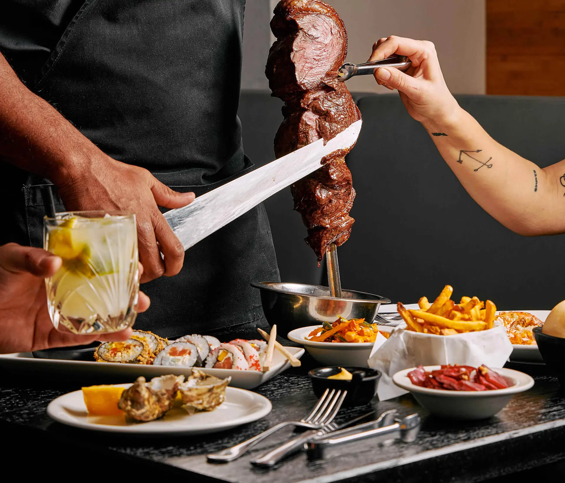 Servírování grilovaného hovězího masa na špízu přímo u stolu v Brasileiru.